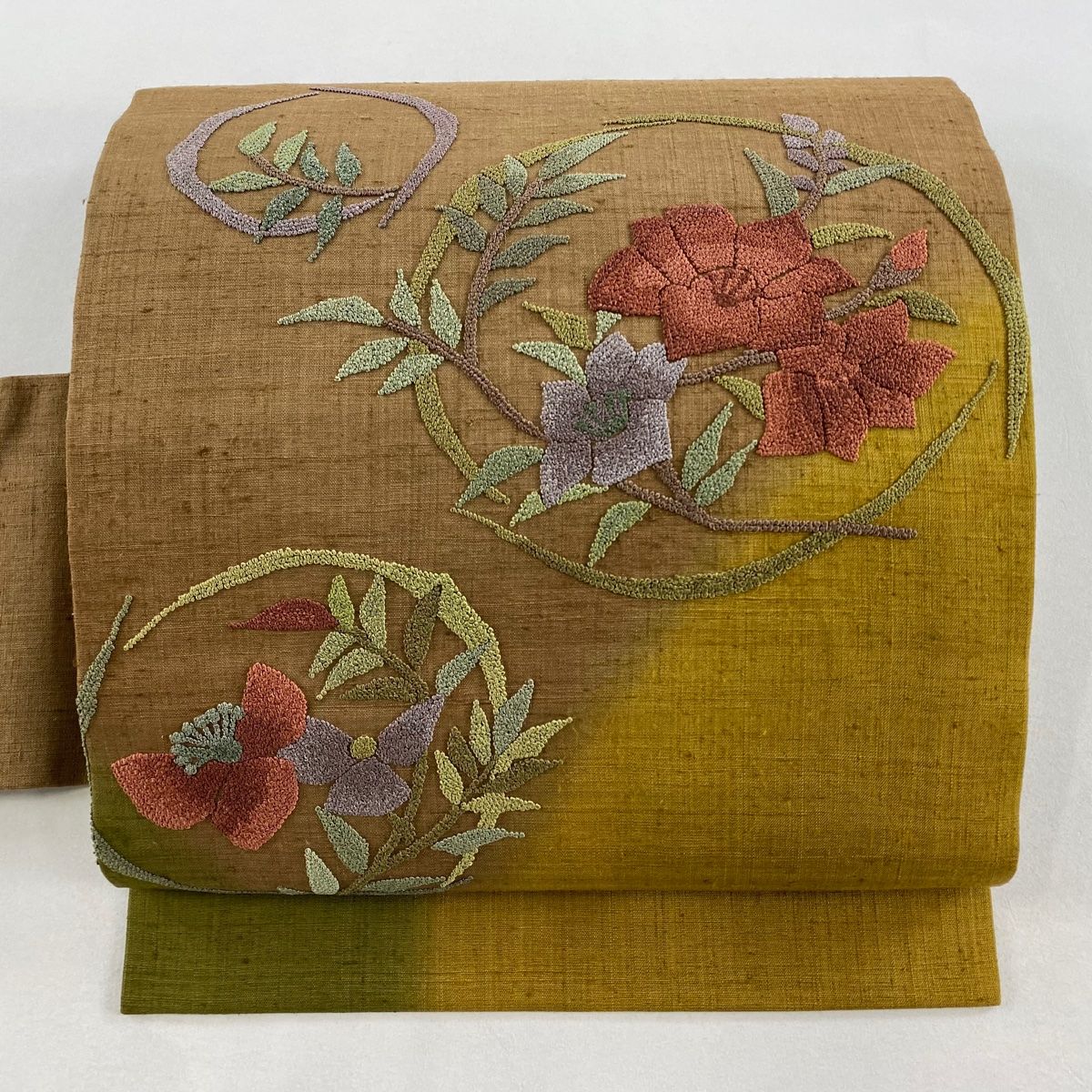 名古屋帯 秀品 紬地 花丸文 相良刺繍 茶色 正絹