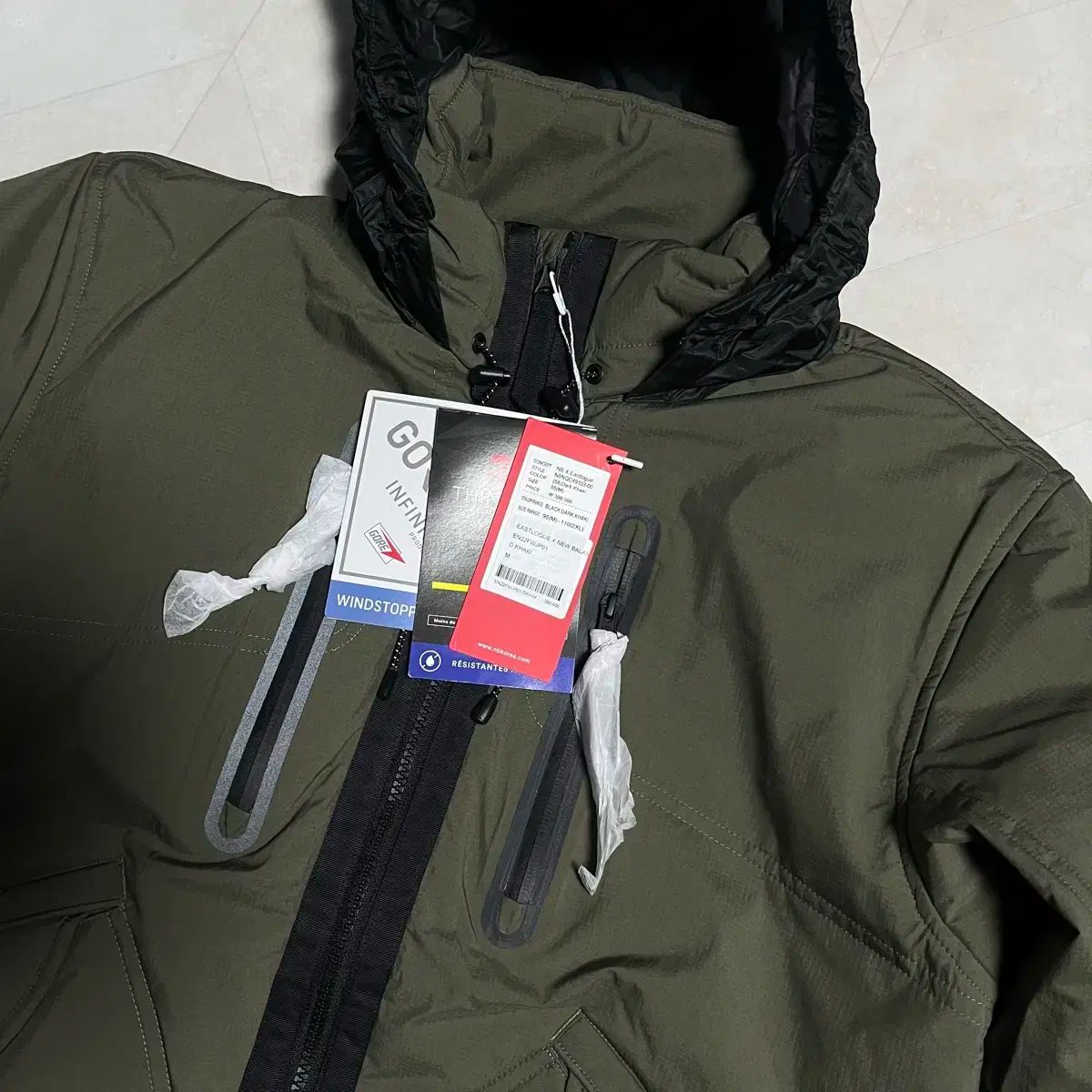 M イーストローグ x ニューバランス パデッド パラトルーパー アウター カーキ