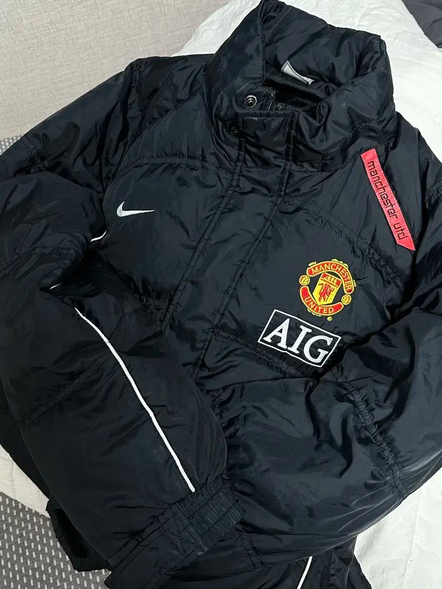NIKE マンチェスターユナイテッド ダウンジャケット刺繍ロゴ　AIG NIKE マンチェスターユナイテッド ダウンジャケット刺繍ロゴ AIG
