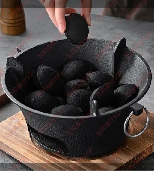 囲炉裏を囲んで茶室内のオーブンを煮る旧式暖房炭ストーブ鋳鉄炭ストーブ