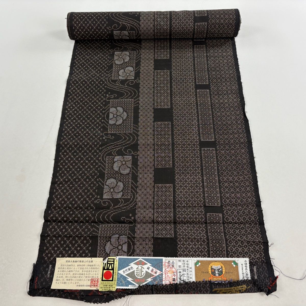 反物 秀品 大島紬 証紙有り ねじ梅 幾何学模様 焦茶色 正絹