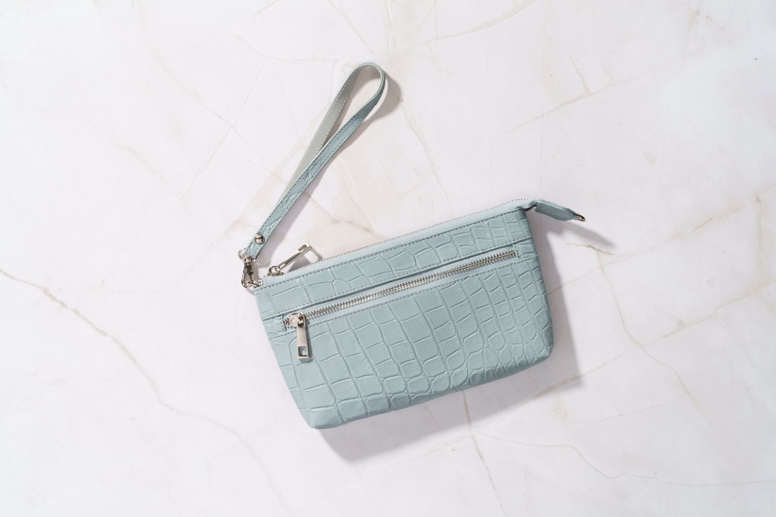 ChatGPT グレー×ライトブルーの クロコダイルが輝く 上質と多機能を備えた大人の ムクラッチポーチ