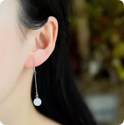 シルバー色のチェーンに白い円形パーツが揺れるシンプルなイヤリング