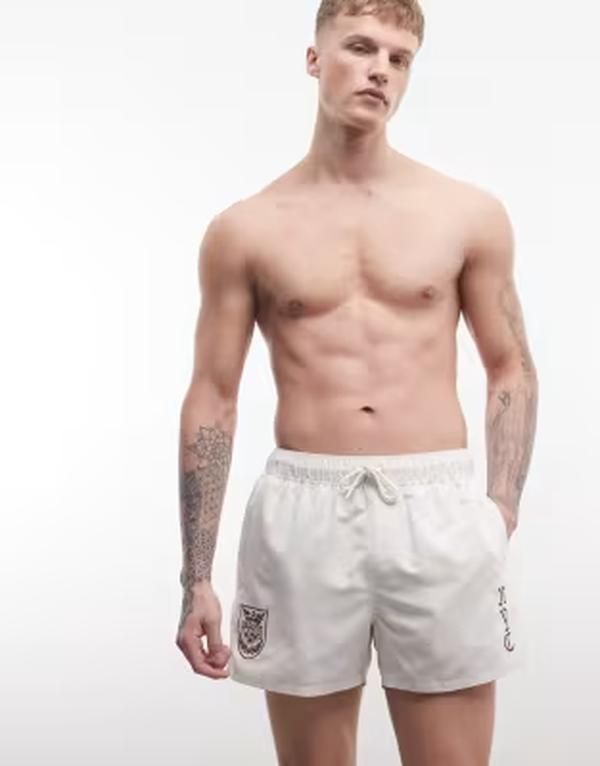 エイソス メンズ 水着 ハーフパンツ・ショーツ ショートパンツ ASOS DESIGN swim shorts in short length with embroidery in cream クリーム
