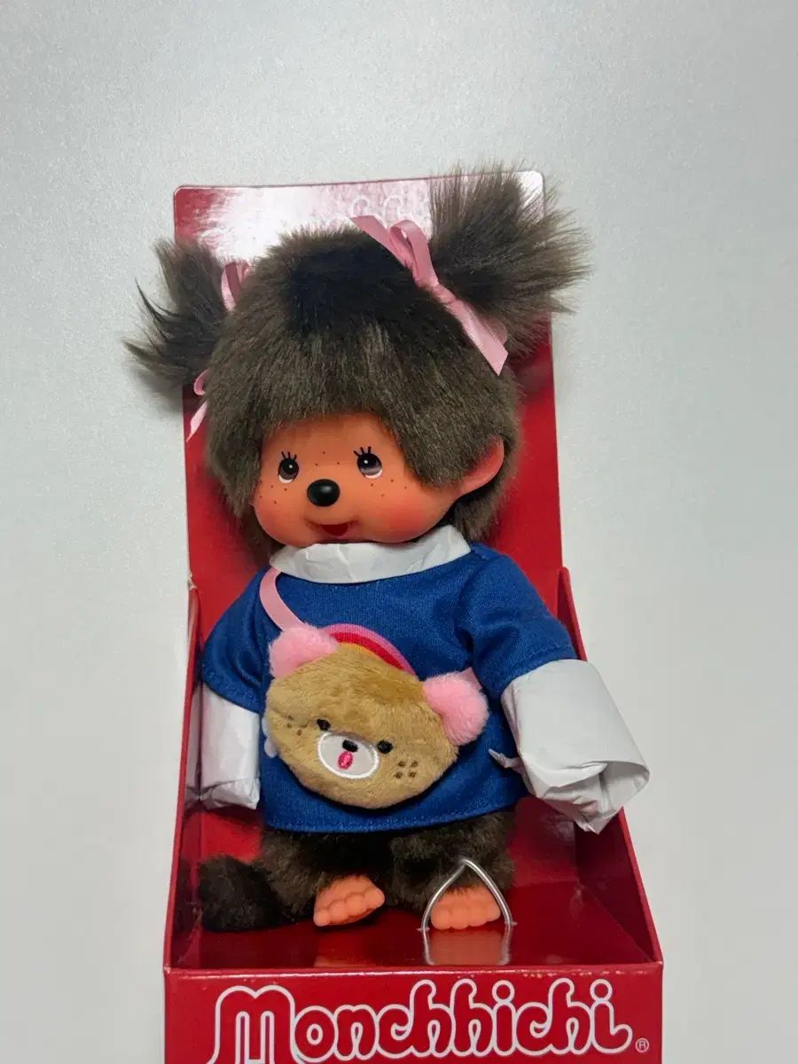 クマのドールを背負ったツインテールのモンチッチ