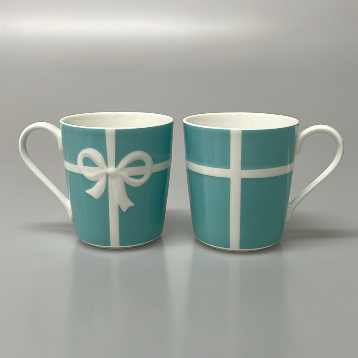 TIFFANY&Co.(ティファニー) マグカップ新品同様 ブルーボウ ライトブルー×白 マグカップ×2点