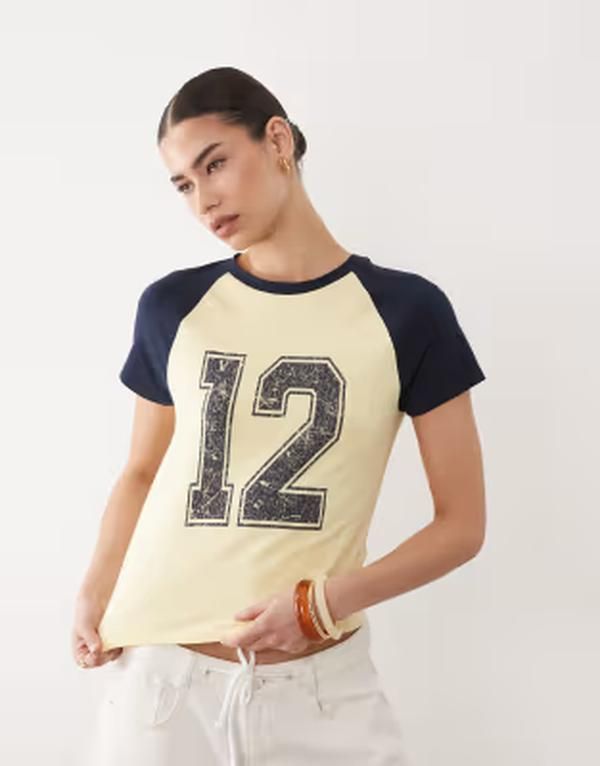 エイソス レディース トップス Tシャツ グラフィック ASOS DESIGN raglan sleeve baby tee with distressed 12 graphic in butterm