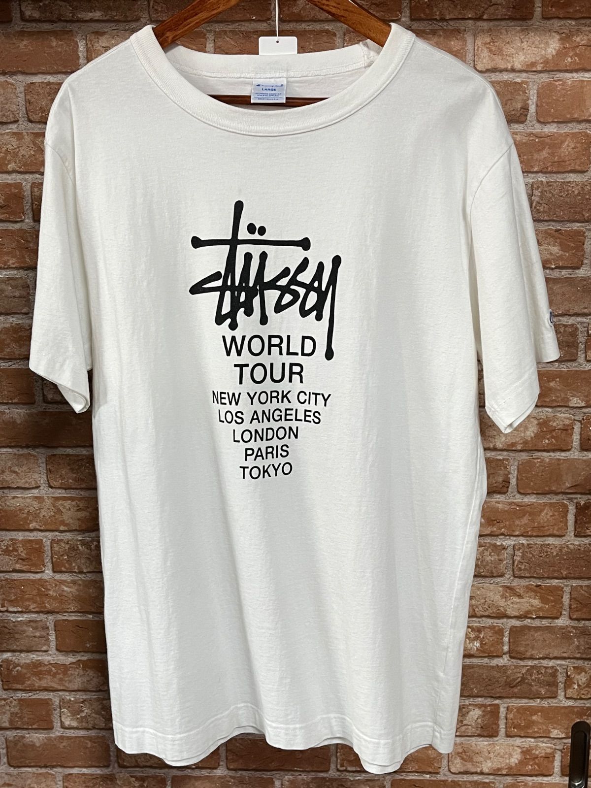STUSSY × Champion WORLD TOUR TEE コラボ L ワールドツアーTシャツ　ロゴ　ホワイト