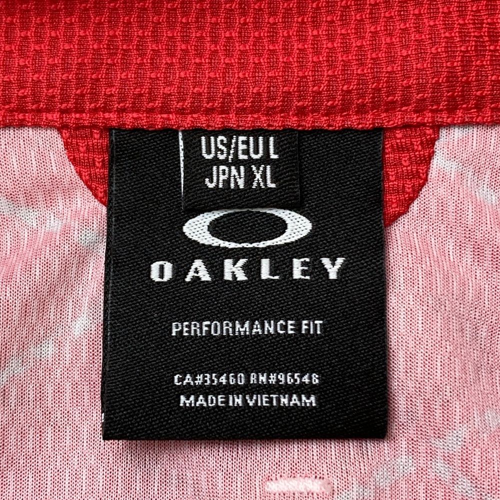 サイズ：XL OAKLEY オークリー  半袖ポロシャツ スカルタグ 総柄 レッド系 [240101474067] ゴルフウェア メンズ ストスト サイズ：XL OAKLEY オークリー 半袖ポロシャツ スカルタグ 総柄