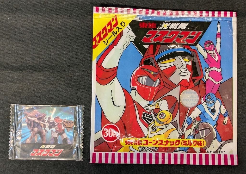 東鳩 菓子パッケージ|マスクマンコーンスナック グレートファイブ中心 右に跳ねてるピンク ミルク味