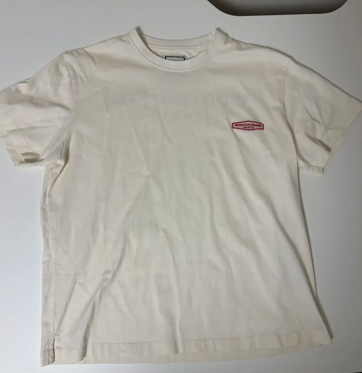 【関税込み】WOOYOUNGMI オフホワイト グラフィックTシャツ Wooyoungmi Men's Back Flower Logo T-Shirt in White Wooyoungmi