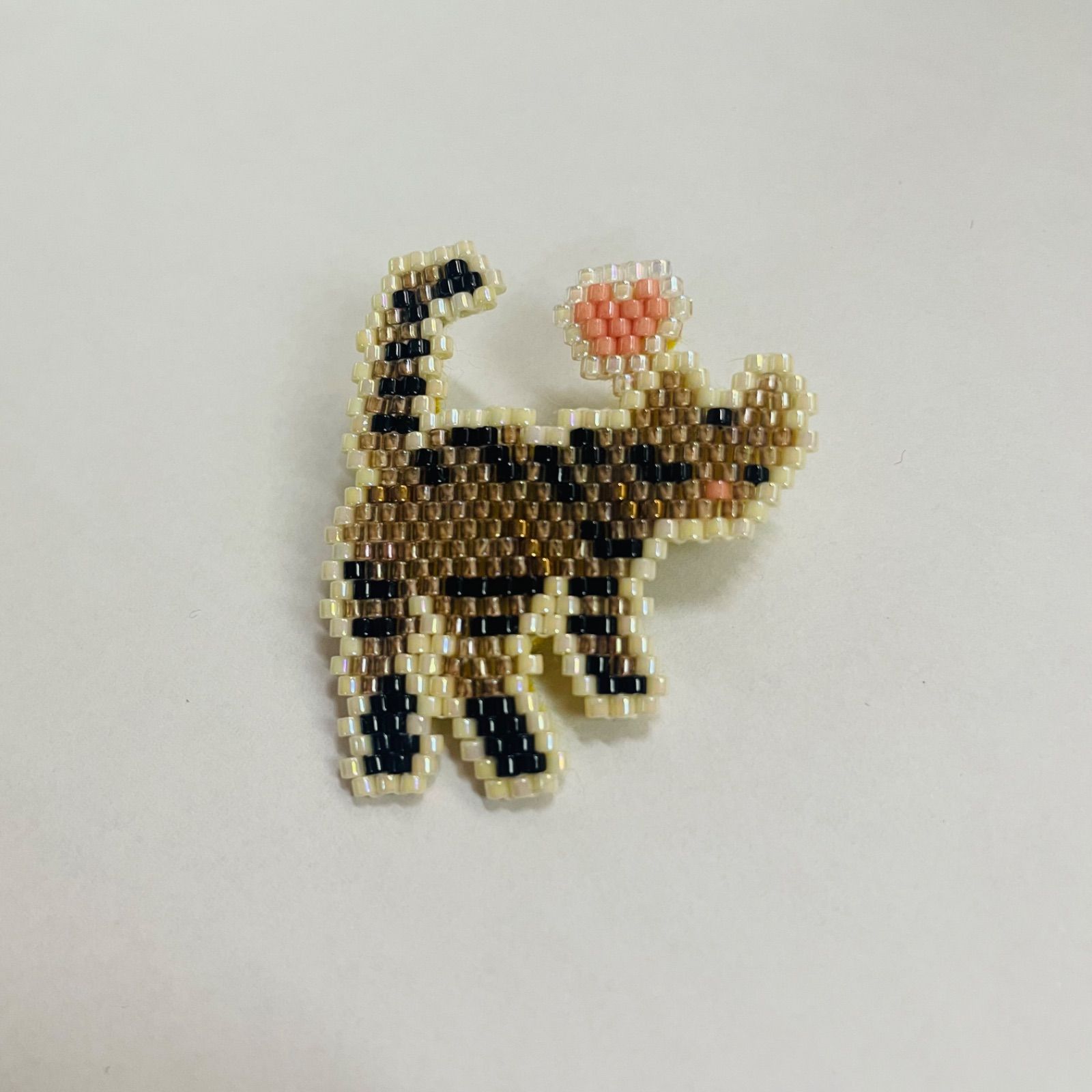 「ついてきて♪」振り返るねこのブローチ・キジトラ