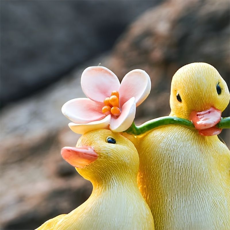 花を咥えているアヒルの子供 2羽