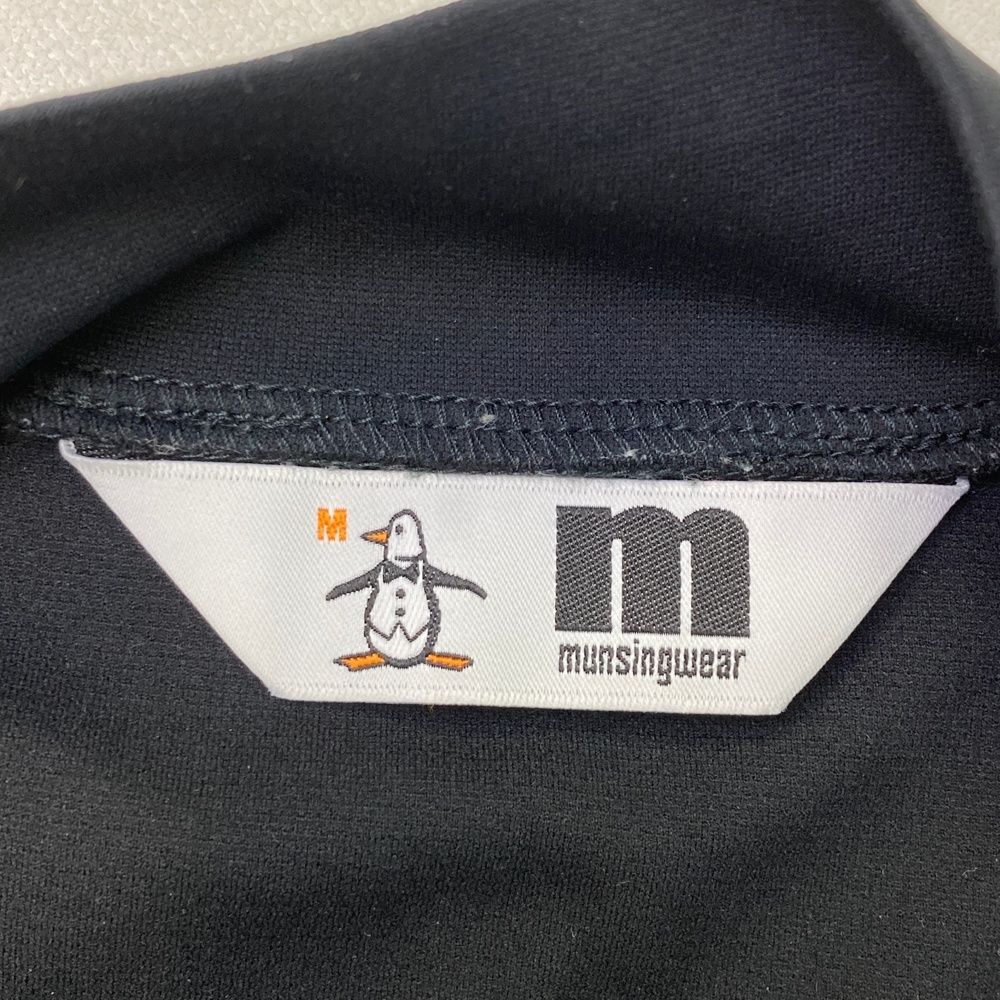 サイズ：M MUNSING WEAR マンシングウェア  ハイネック 長袖Tシャツ ロゴ  ブラック系 [240101475117] ゴルフウェア メンズ ストスト サイズ：M MUNSING WEAR マンシングウェア ハイネック 長袖T