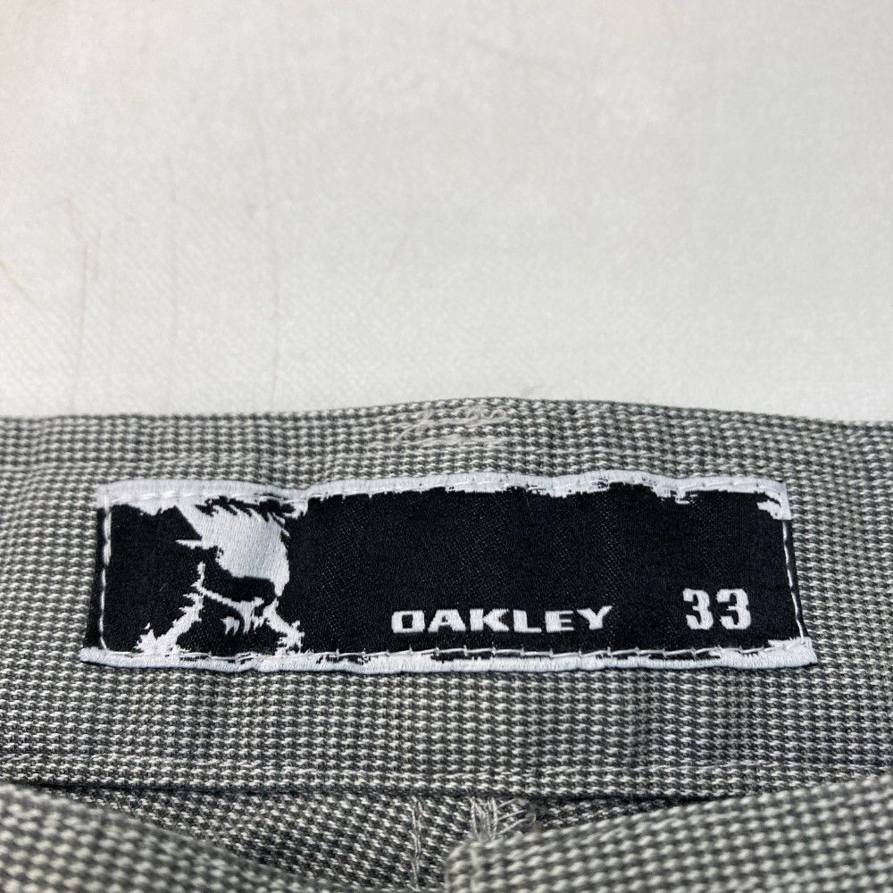 サイズ：33 OAKLEY オークリー  ストレッチパンツ 総柄 スカル刺繍 グレー系 [240101421982] ゴルフウェア メンズ ストスト サイズ：33 OAKLEY オークリー ストレッチパンツ 総柄 スカル