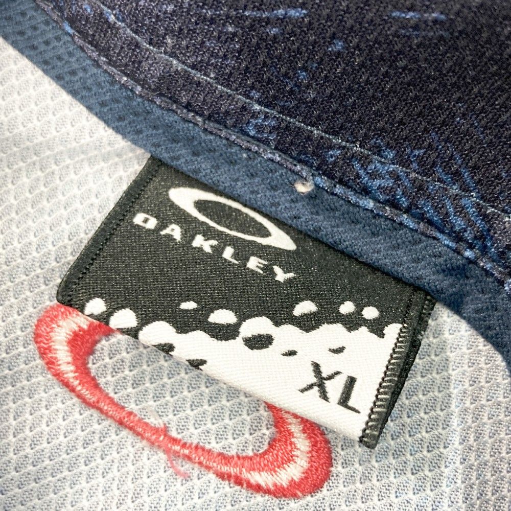 サイズ：XL OAKLEY オークリー 433627JP 半袖ポロシャツ ボタンダウン 総柄 ネイビー系 [240101421949] ゴルフウェア メンズ ストスト サイズ：XL OAKLEY オークリー 433627JP 半袖ポロシャツ ボタン