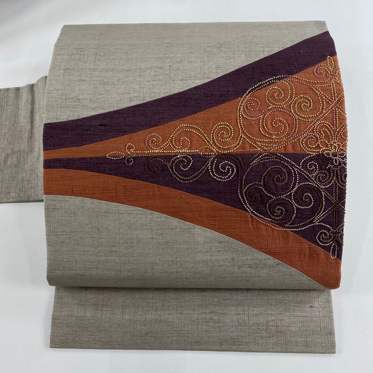 名古屋帯 秀品 幾何学 相良刺繍 茶紫 正絹