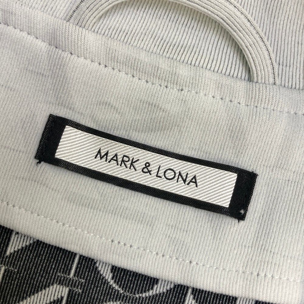 サイズ：48 MARK&LONA マークアンドロナ  ジップジャケット ロゴ総柄 ホワイト系 [240101461282] ゴルフウェア メンズ ストスト サイズ：48 MARK&LONA マークアンドロナ ジップジャケット ロゴ