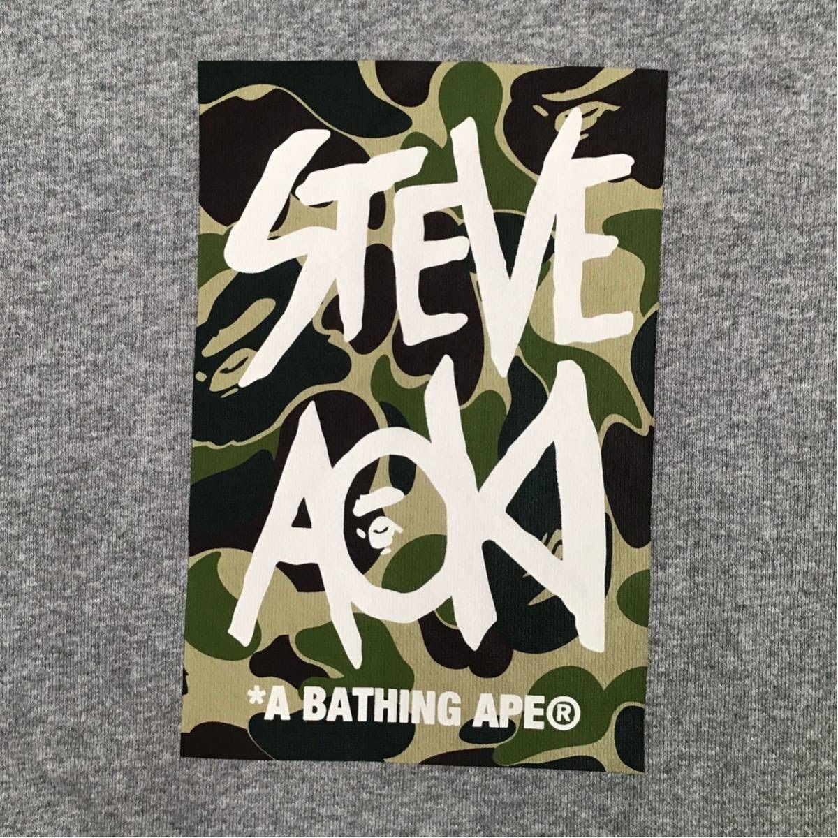 AAPE steve aoki コラボ パーカー ベイプ×スティーヴ・アオキ、カモ柄にロゴを重ねたTシャツ