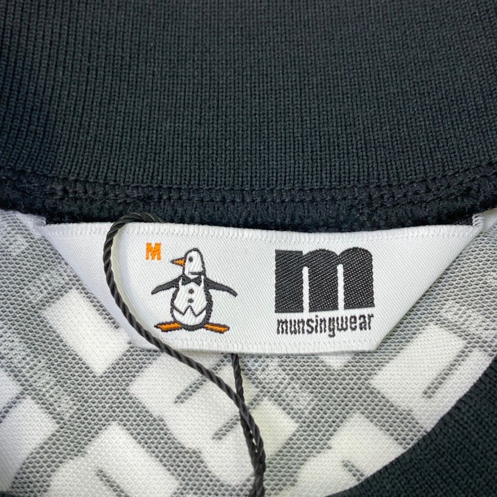 サイズ：M MUNSING WEAR マンシングウェア  半袖モックネックTシャツ 総柄 ブラック系 [240101446514] ゴルフウェア メンズ ストスト サイズ：M MUNSING WEAR マンシングウェア 半袖モックネックTシャツ 総