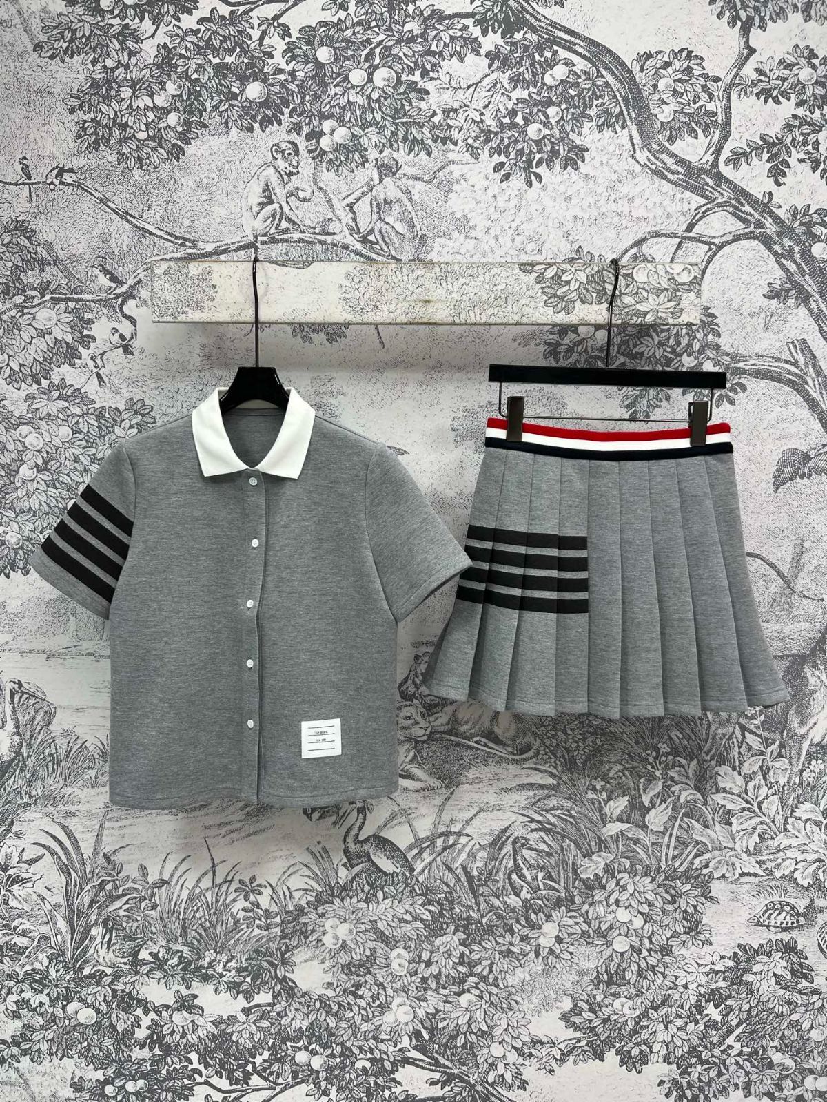 THOM BROWNE の であるポロネックの短袖ストライプシャツとハイウエストのプリーツスカートから成るキャンパス風セット