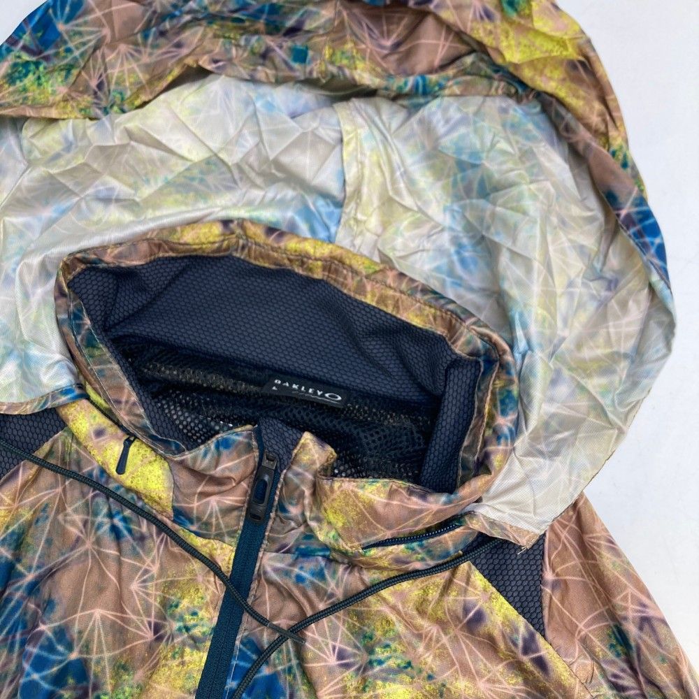 サイズ：L OAKLEY オークリー  2WAY裏メッシュ ジップジャケット 総柄 ブラウン系 [240101465640] ゴルフウェア メンズ ストスト サイズ：L OAKLEY オークリー 2WAY裏メッシュ ジップジャケット