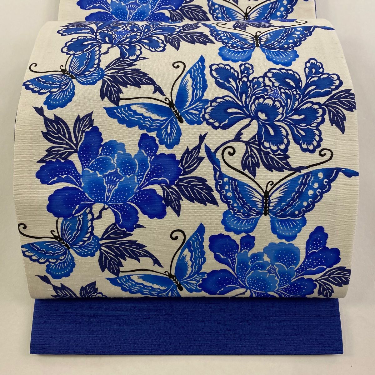 美品】 袋帯 逸品 落款 知念初子 琉球びんがた 牛首紬地 草花 蝶 藍色