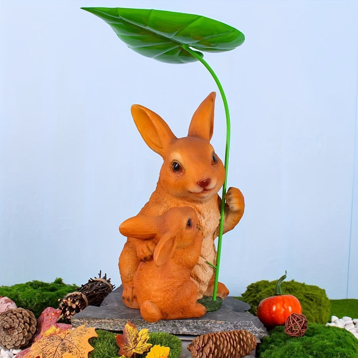 葉っぱの傘をさしているウサギの親子