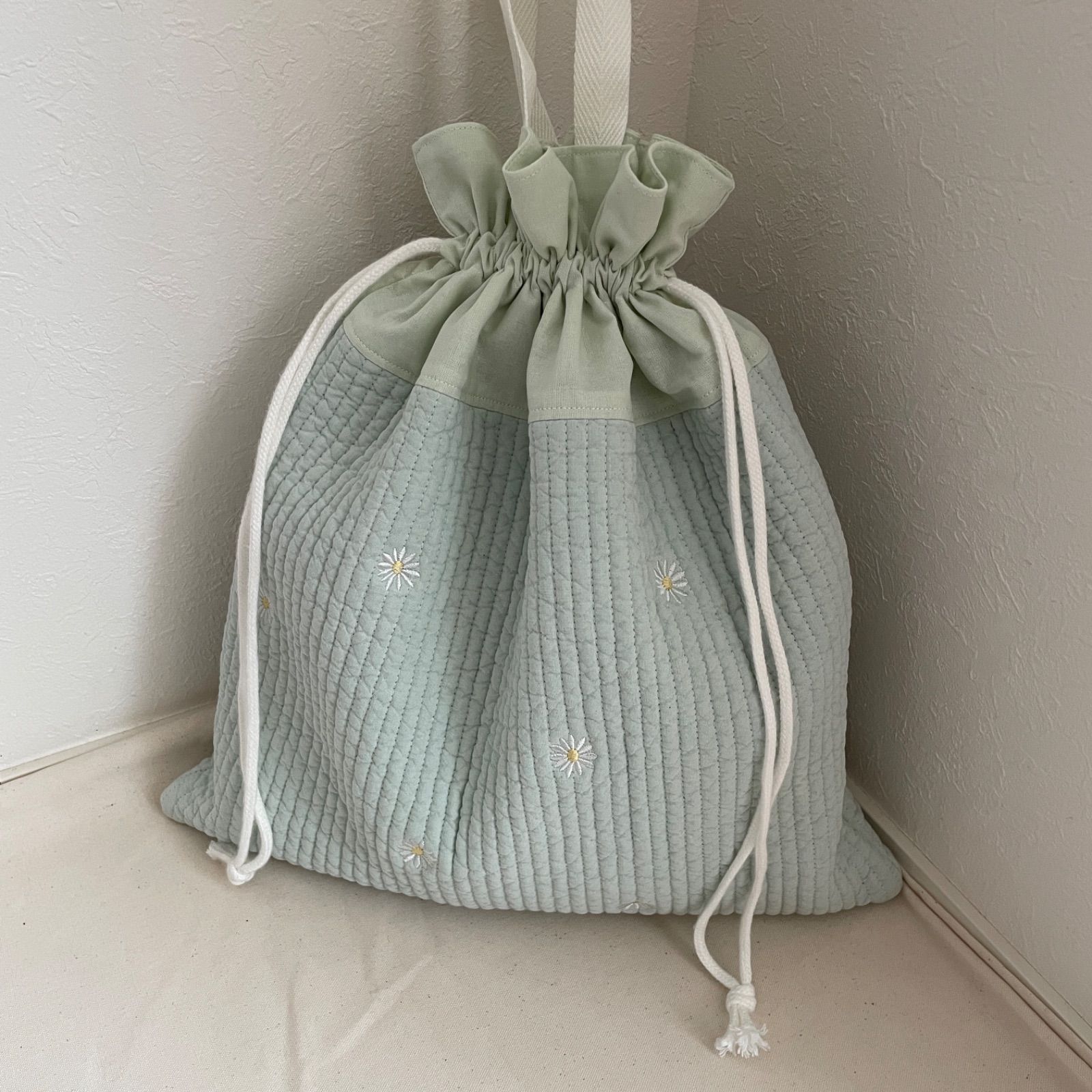 巾着袋　哺乳瓶ケース　お着替え袋　ヌビ　マーガレット刺繍　ハート刺繍 マーガレット刺繍生地×手刺繍のミニ巾着(あずきミルク