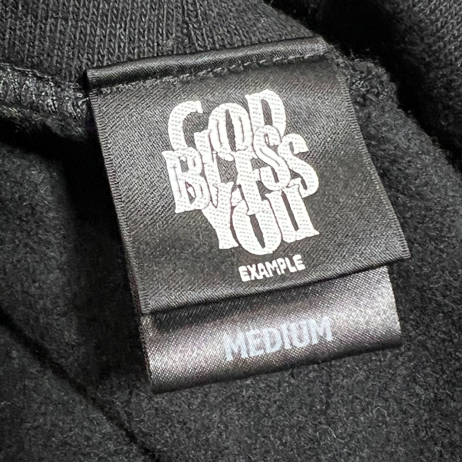 人気ブランド【EXAMPLE】の「GOD BLESS YOU」裏起毛ロゴ フーディー 