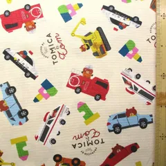 約108×40  8209 キャラクター 生地  トミカ と トム （ クリームベージュ系)  トミカ生地 トミカ 生地 はたらく 車 消防車 救急車 パトカー クリーム ベージュ