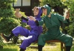 【中古】生写真(男性) 渡辺和貴(潮江文次郎)・佐藤流司(田村三木エ門)/横型・衣装紫・緑・座り・本・足上げ・キャラクターショット/ミュージカル 忍たま乱太郎 生写真