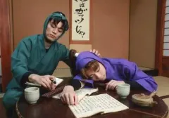 【中古】生写真(男性) 佐藤流司(田村三木エ門)・渡辺和貴(潮江文次郎)/横型・衣装緑・紫・机・うつ伏せ・本・キャラクターショット/ミュージカル「忍たま乱太郎」第四弾 「最恐計画を暴き出せ!!」再演 生写真