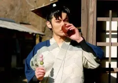 【中古】生写真(男性) 渡辺和貴(潮江文次郎)/横型・バストアップ・衣装青・グレー・右手団子・左手湯のみ・建物・野外・キャラクターショット/ミュージカル「忍たま乱太郎」第五弾再演～新たなる敵!～