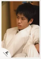 【中古】生写真(ジャニーズ) 嵐/二宮和也/上半身・衣装ジャケット白・座り・足組み・背景茶/公式生写真