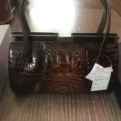 新品、光沢のあるブラウンのクロコダイルレザー製ハンドバッグ。