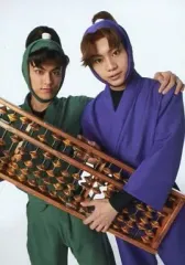 【中古】生写真(男性) 渡辺和貴(潮江文次郎)・佐藤流司(田村三木エ門)/膝上・衣装緑紫・算盤・背景白・キャラクターショット/ミュージカル「忍たま乱太郎」第四弾 「最恐計画を暴き出せ!!」