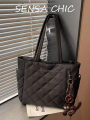 バッグ レディース トートバッグ この女性用ハンドバッグは、キルティングデザインの純黒ポリエステル生地で作られており、小さなクマのクッキーのペンダントで装飾されています。両サイドにカップホルダーがあり、上部にはメタ