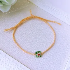 グリーンのミルフィオリガラスとオレンジのワックスコード三つ編みブレスレット（ホワイト花柄）