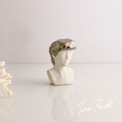 Artwork: Miniature ceramic fève (small ceramic figurine) of a bust of the statue of David, made in France.