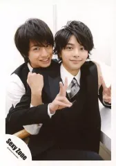 【中古】生写真(ジャニーズ) Sexy Zone/中島健人・佐藤勝利/膝上・衣装黒・白・佐藤両手ピース・口閉じ・中島両手佐藤両腕・歯見せ・背景白/JOHNNYS’ World パンフ＆グッズ 撮影オフショット/公式生写真