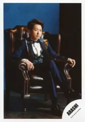 【中古】生写真(ジャニーズ) 嵐/大野智/全身・衣装黒・白・青・赤・黄色・チェック柄・座り・右向き・足組み・ソファ茶色・背景青/アルバム「5×20 All the BEST!! 1999-2019」MV＆ジャケ写オフショット/公式生写真