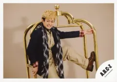 【中古】生写真(ジャニーズ) A.B.C-Z/塚田僚一/横型・膝上・衣装黒ベージュ・赤チェック柄・ストール・両手金のオブジェ・左足上げ・体右向き・目線左下・歯見せ・背景ベージュ/公式生写真