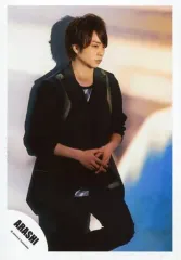 【中古】生写真(ジャニーズ) 嵐/櫻井翔/膝上・衣装黒・両手重ね・体右向き・左足曲げ・背景茶ベージュ青/「復活LOVE」PV＆ジャケ写撮影オフショット/公式生写真