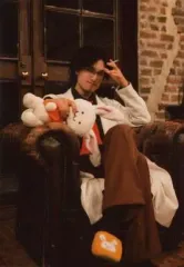 【中古】生写真(男性) 唐橋充(ニィ健一)・藤田玲(健邑)/全身・座り・衣装白・黒・茶色・眼鏡・右手うさぎのぬいぐるみ・左手たばこ・口閉じ・右向き・足組み・ソファ茶色・キャラクターショット/舞台「最遊記歌劇伝-Burial-」桃源郷ブロマイド