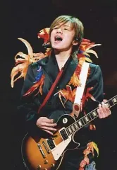 【中古】生写真(ジャニーズ) 関ジャニ∞/安田章大/ライブフォト・上半身・衣装黒・赤・オレンジ色の羽根・両手ギター・口開け・目線上・枠無し/クリスマスパーティー限定公式生写真