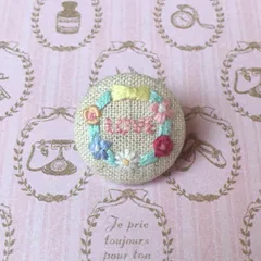 くるみボタン刺繍ブローチ「花とリボンのリース」(ナチュラル)綿麻布