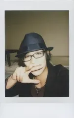 【中古】生写真(男性) ギルド/YOSHIHIRO/バストアップ・衣装黒グレー・帽子・眼鏡・右手指3本立て前・首傾げ・背景白/生チェキ