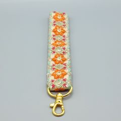 [149]インド刺繍リボンのスマホ用ハンドストラップ（生成り・オレンジ系、金具：ゴールド系）、ハンドメイド